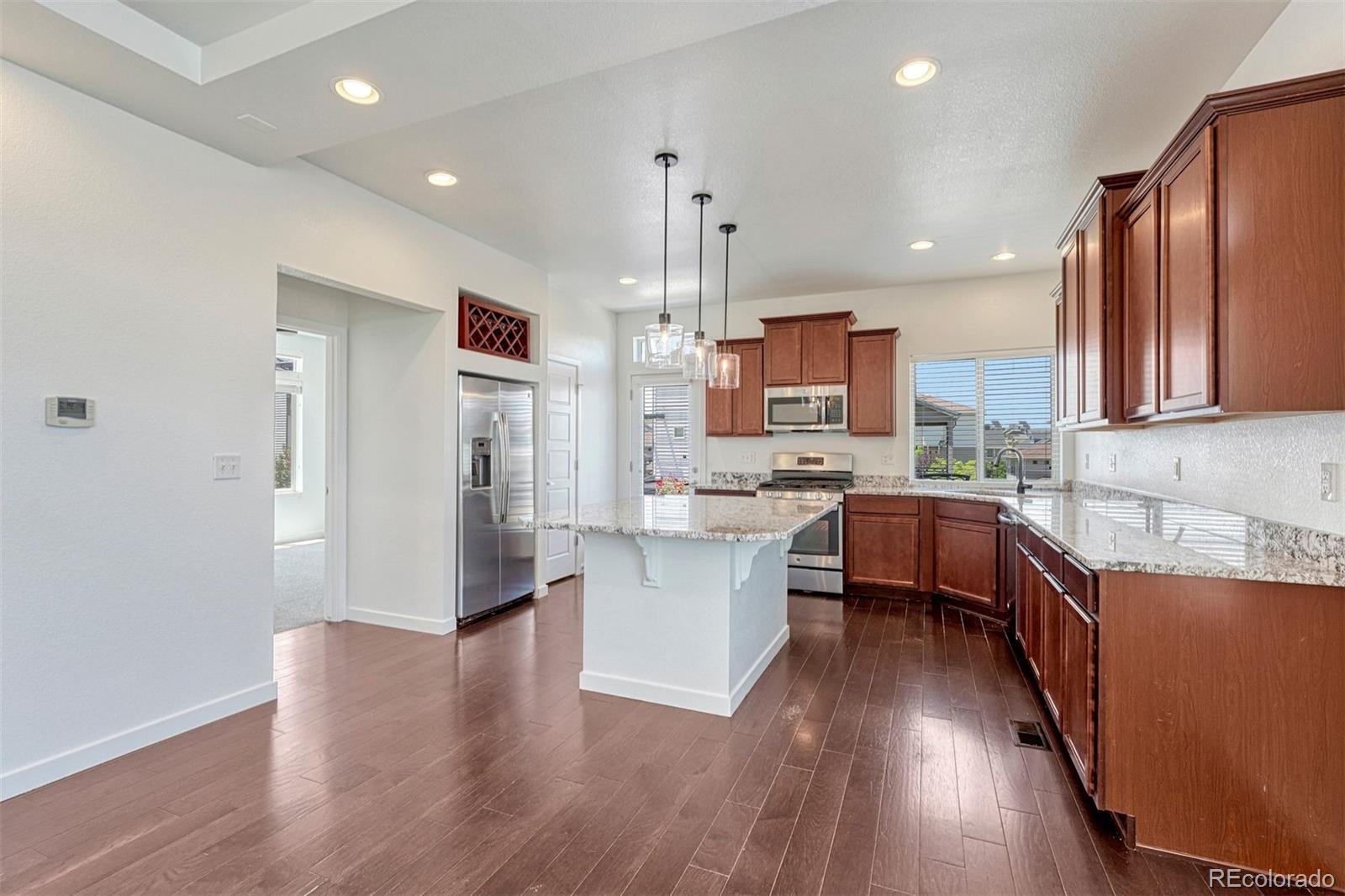 a kitchen with stainless steel appliances wooden floors and wooden cabinets