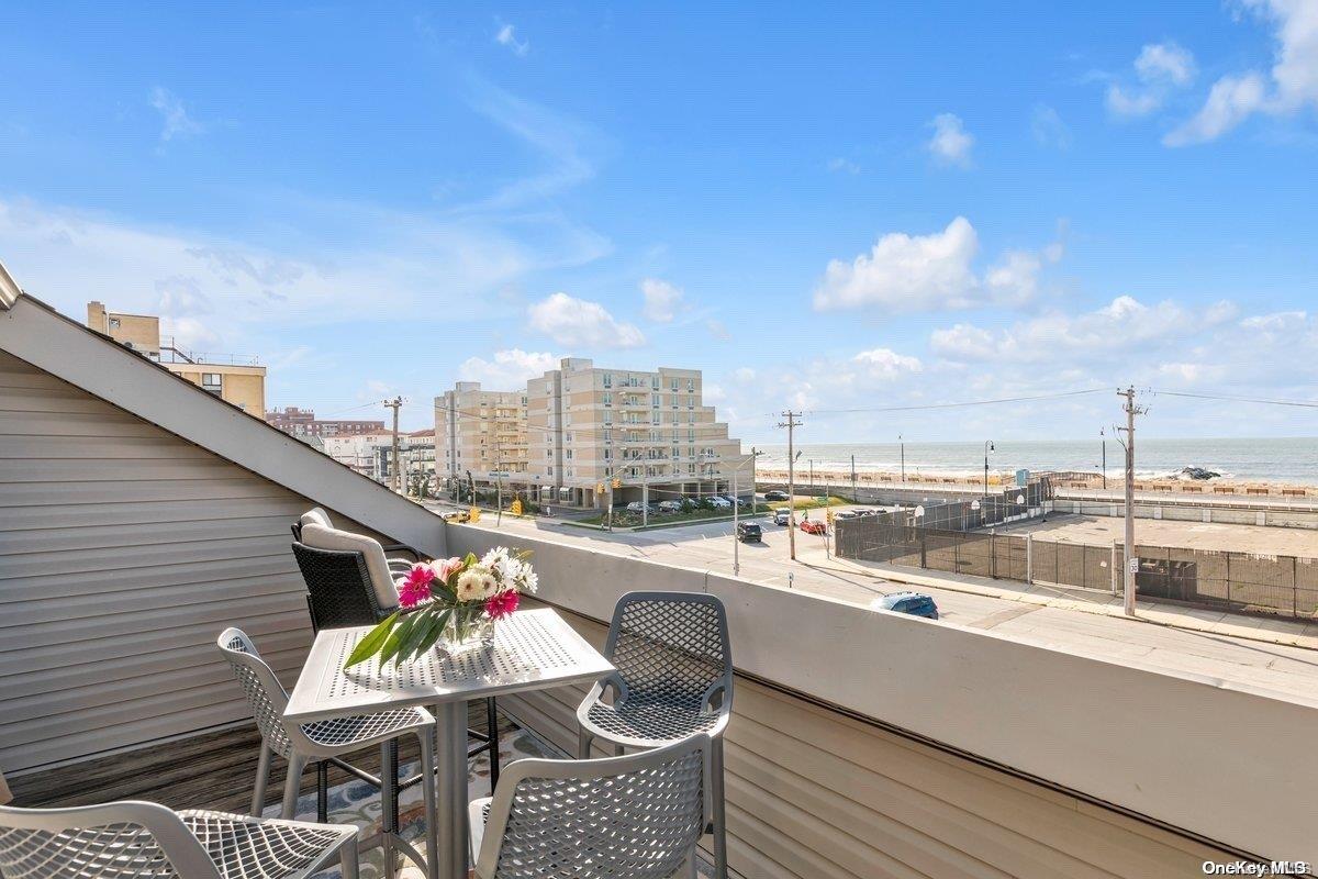 a city view from a balcony with furniture