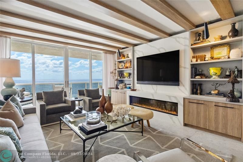 a living room with furniture a flat screen tv and a floor to ceiling window