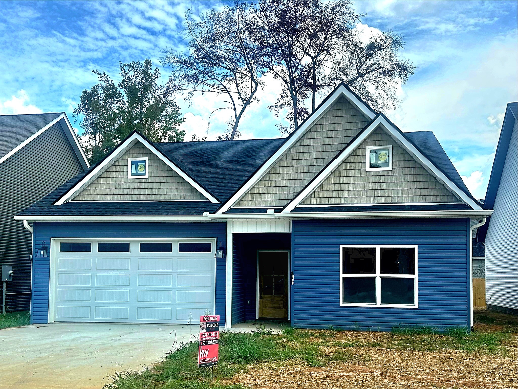 a front view of a house with a yard and garage