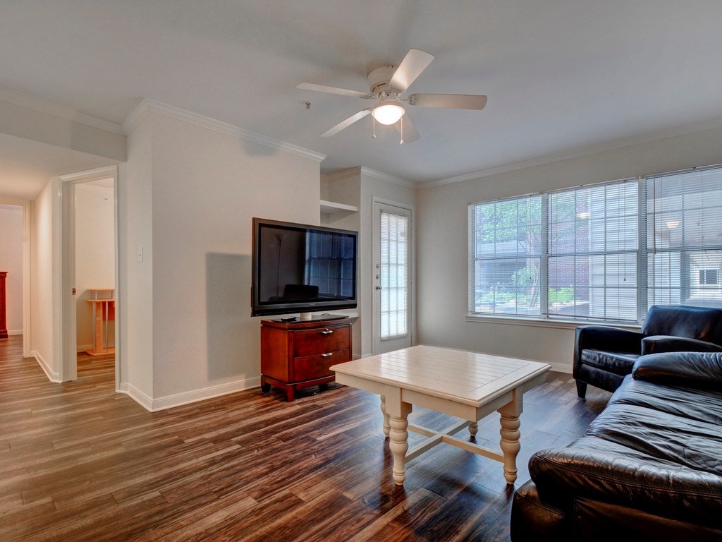 a living room with furniture a flat screen tv and kitchen view