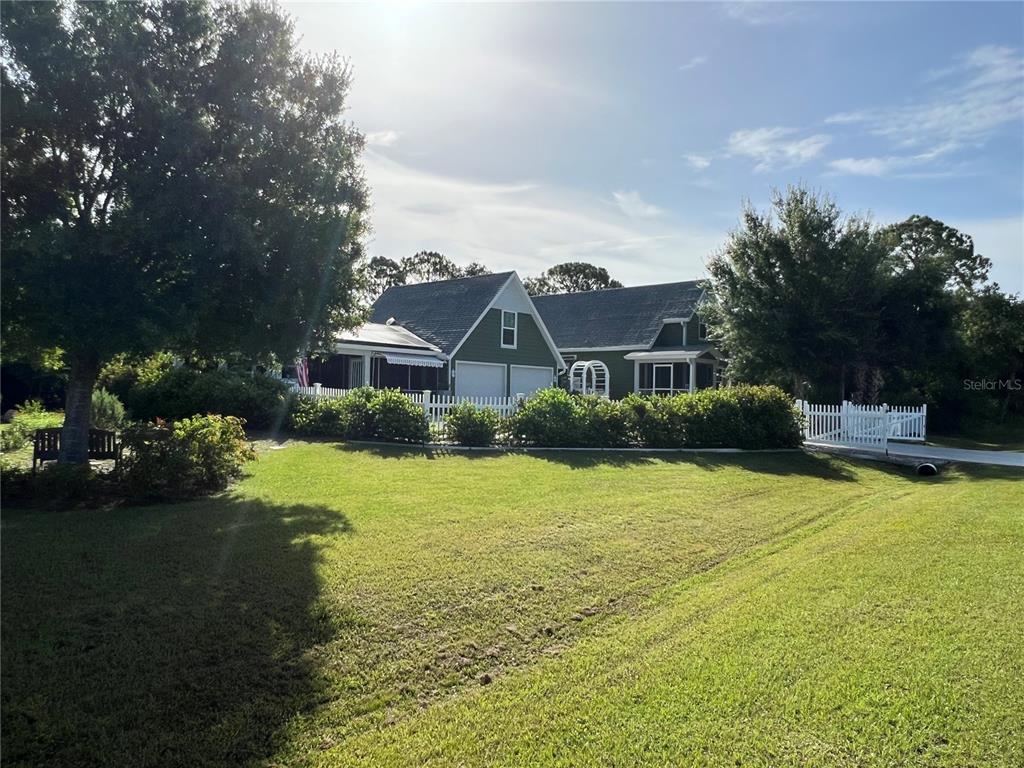 a view of a house with swimming pool next to a yard