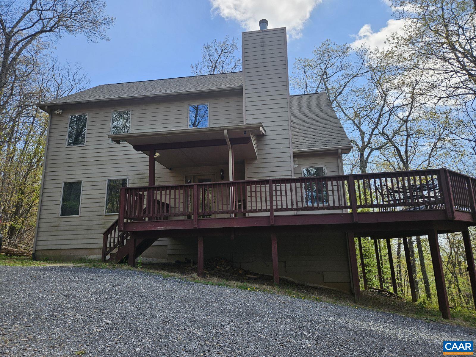 a view of a house with wooden deck front of house