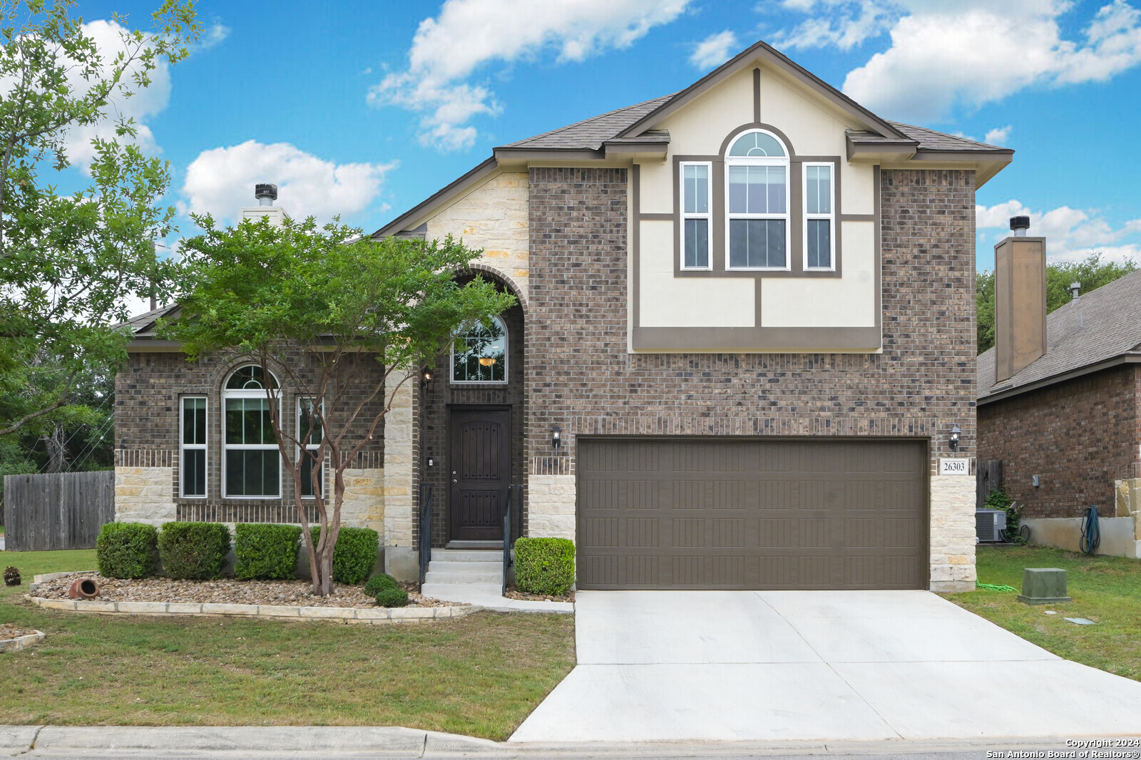 a front view of a house with a yard and garage