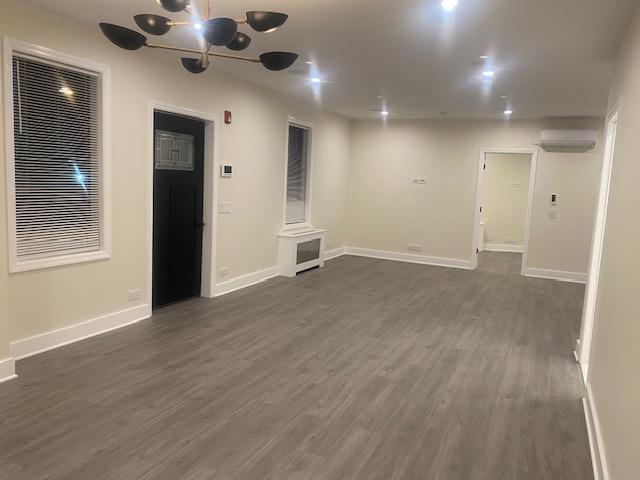 an empty room with wooden floor and a ceiling fan