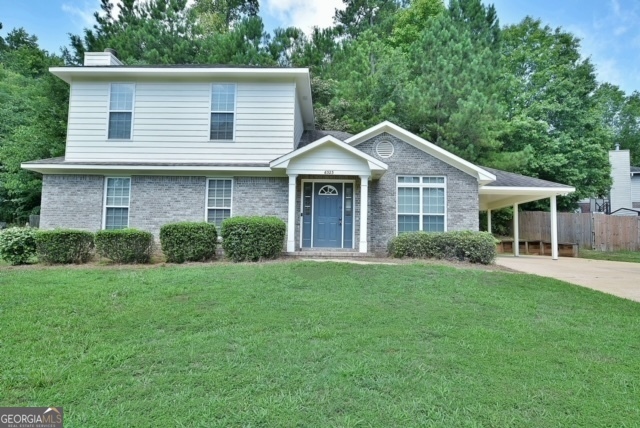 a front view of a house with a garden