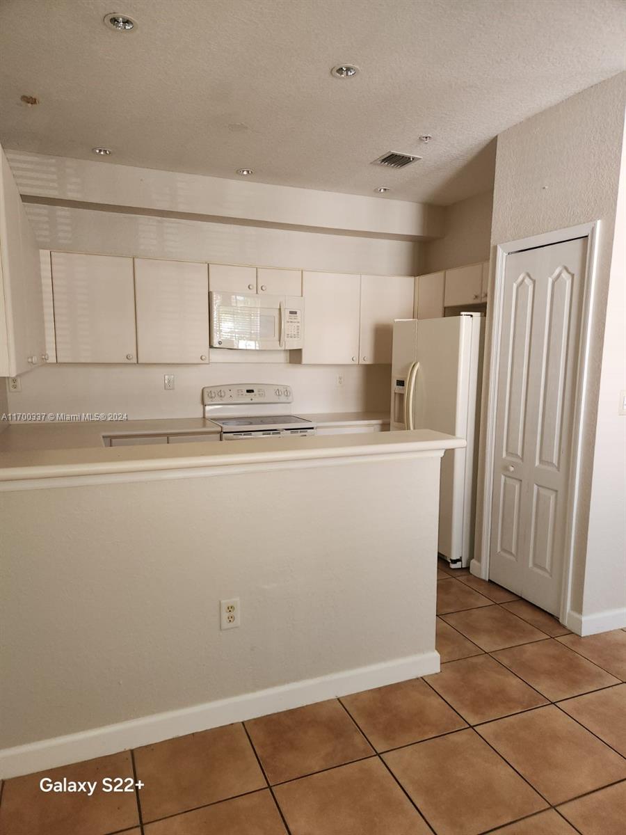 a utility room with cabinets washer and dryer