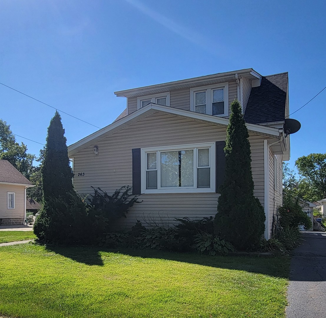 a front view of a house with a garden