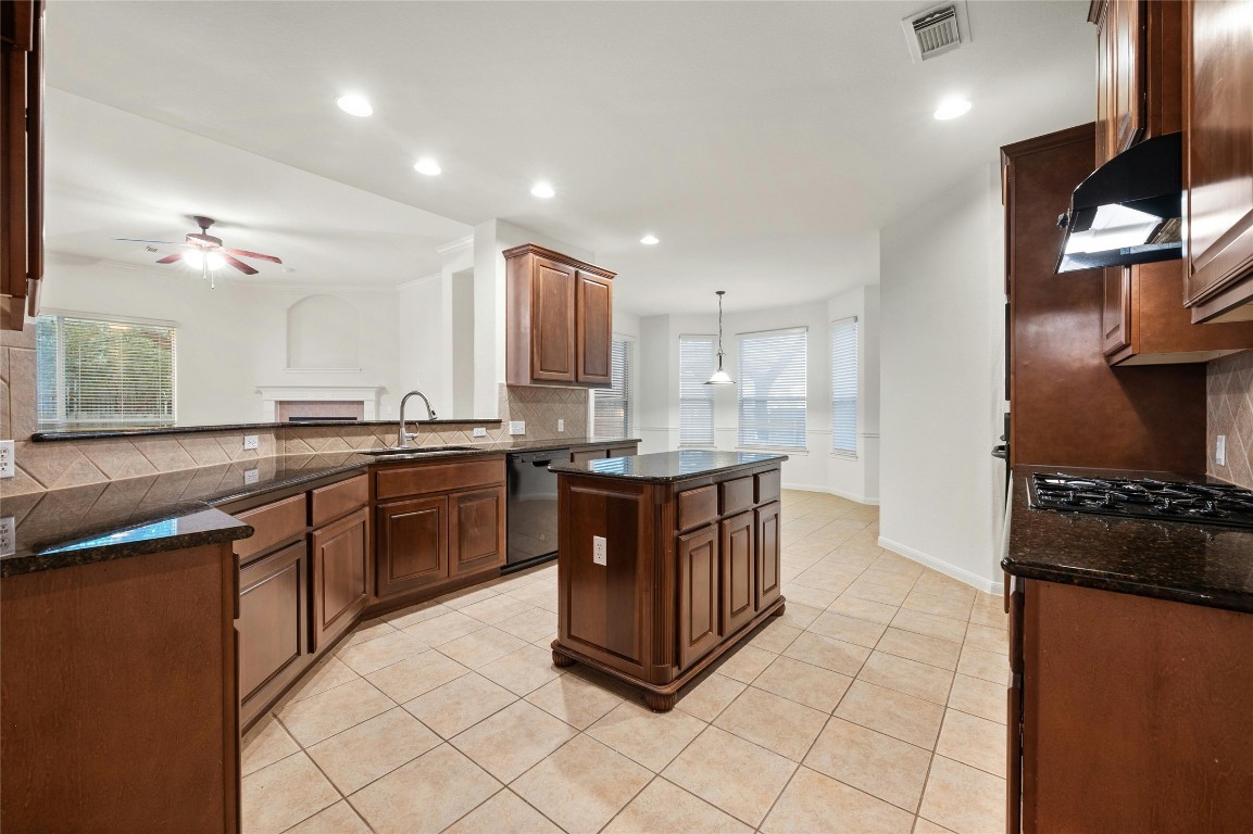 a kitchen with stainless steel appliances granite countertop a stove a sink and a refrigerator