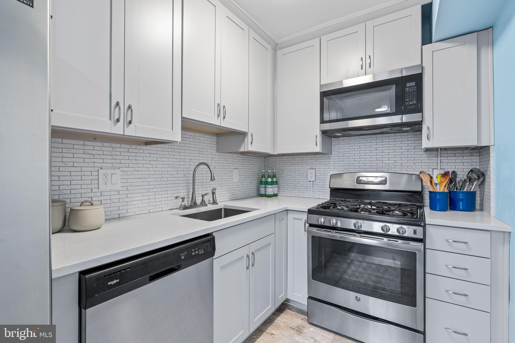 a kitchen with white cabinets and appliances