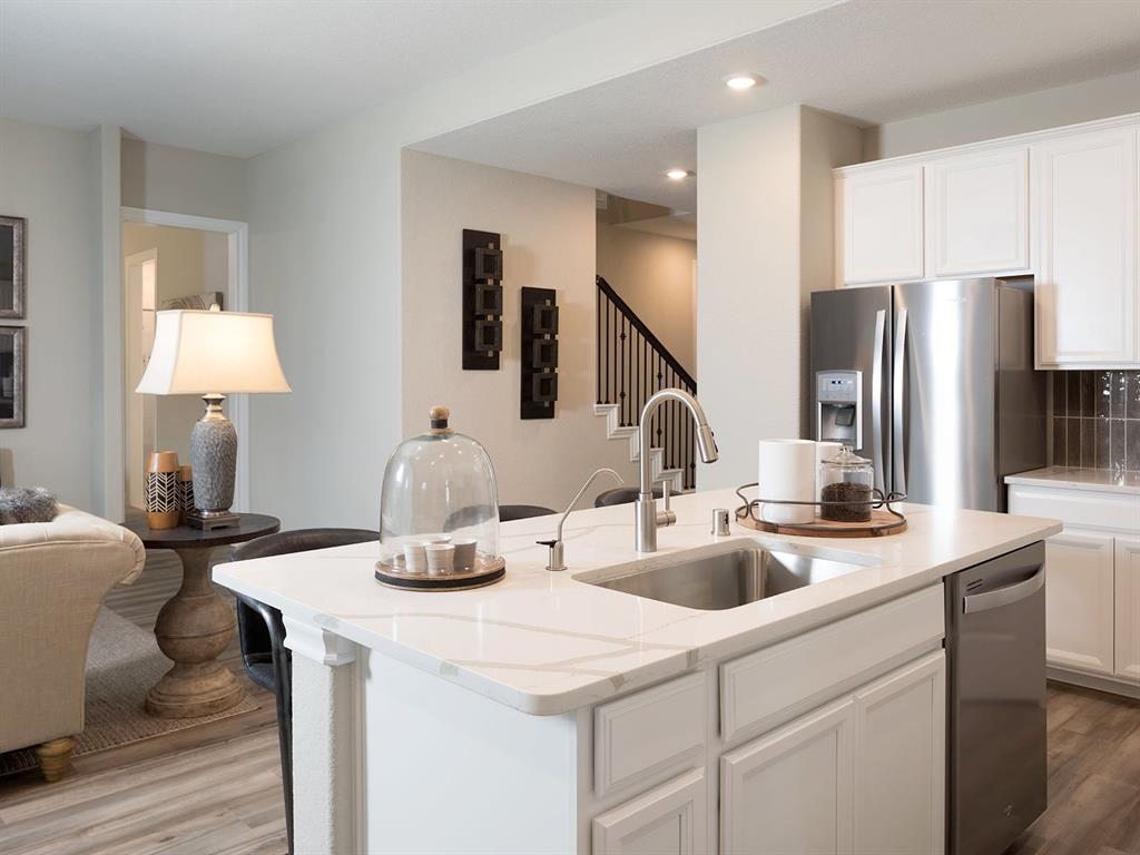 a kitchen with stainless steel appliances kitchen island a sink stove and refrigerator