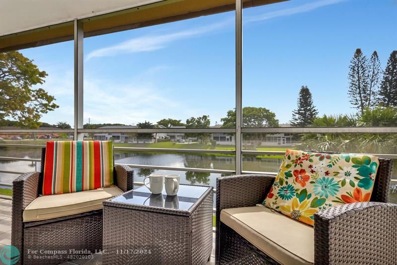 a view of a balcony with wooden floor and outdoor seating