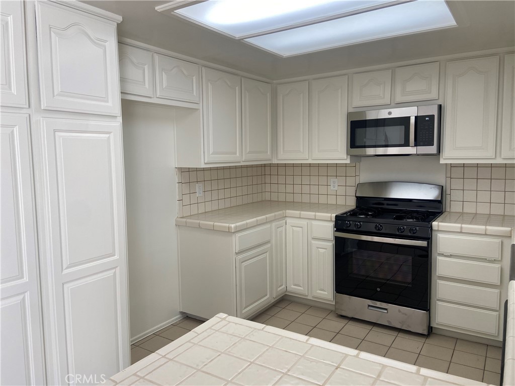 a kitchen with stainless steel appliances granite countertop a stove and a microwave