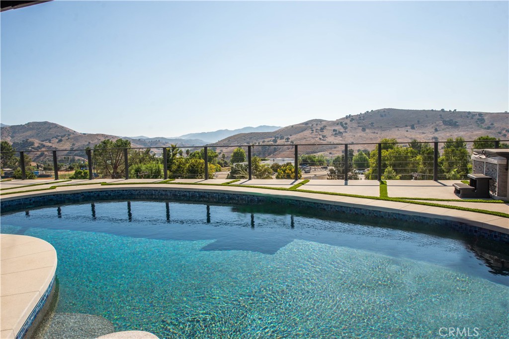 a view of swimming pool with outdoor seating and a garden