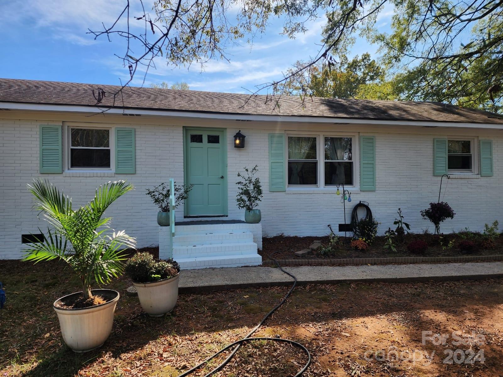 a front view of a house with potted plants