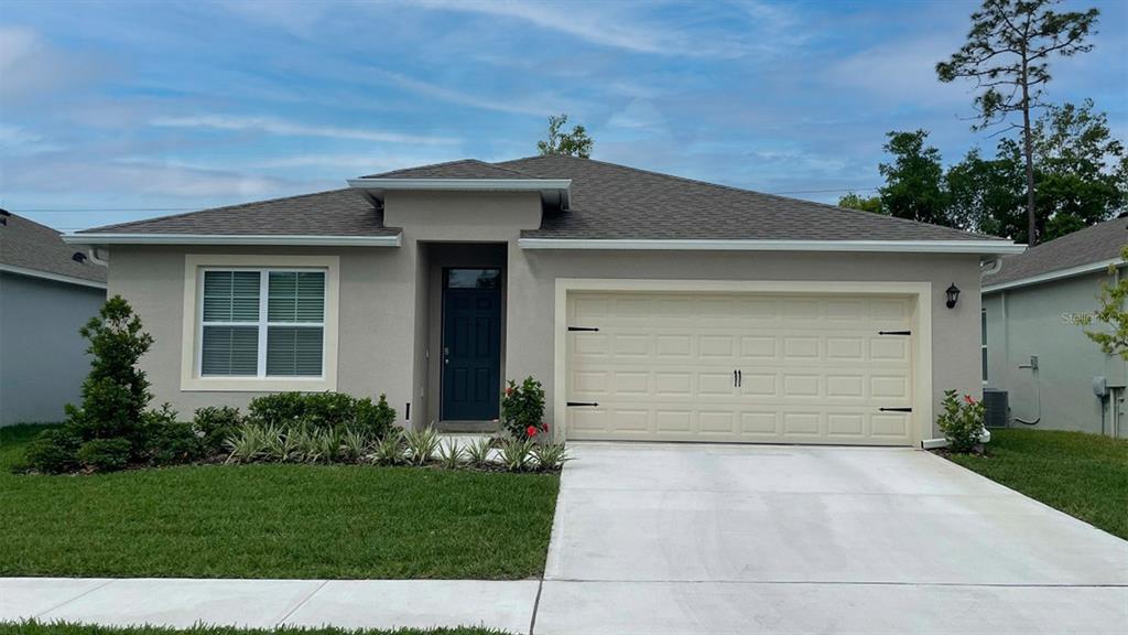 a front view of a house with a yard and garage