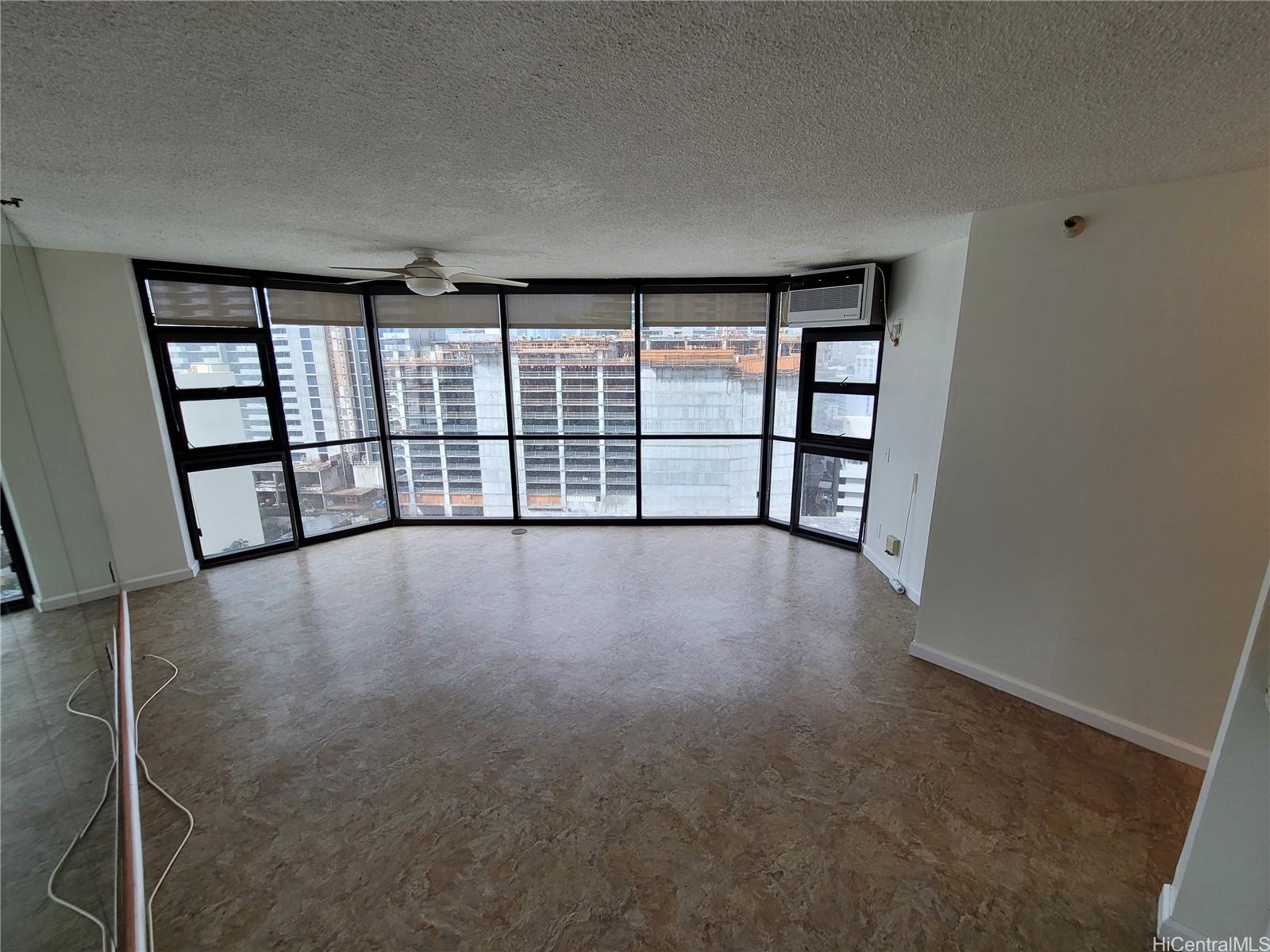 an empty room with windows and wooden floor