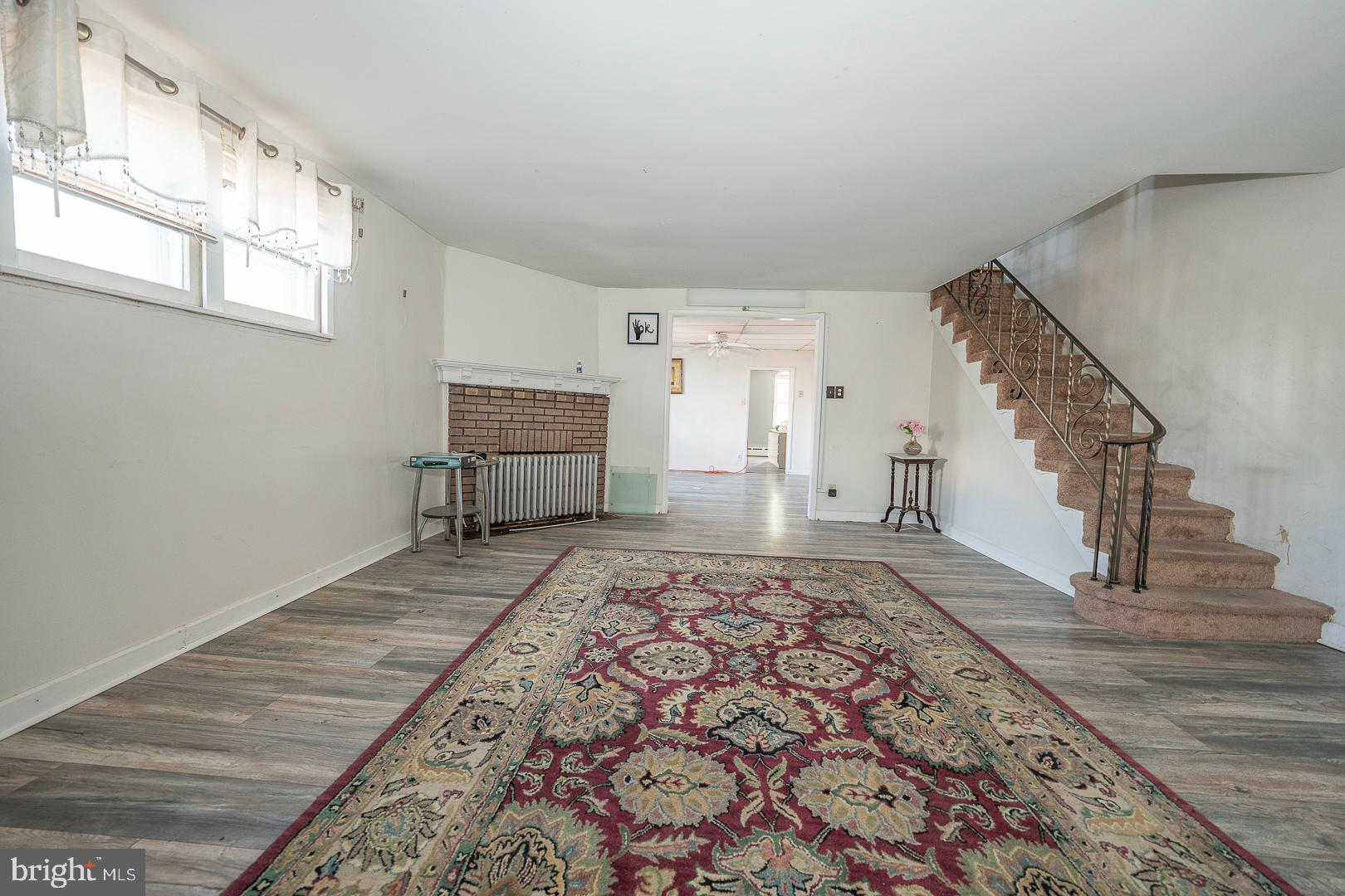 a view of a bedroom with wooden floor and white walls