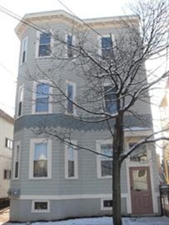 a large brick building with a tree in front of it