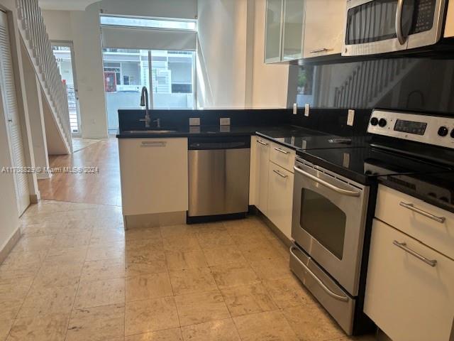 a kitchen with granite countertop a stove a sink and a microwave