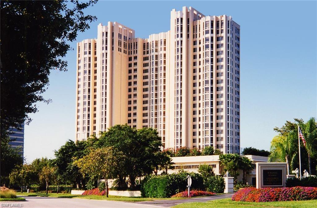 a view of a tall building next to a yard