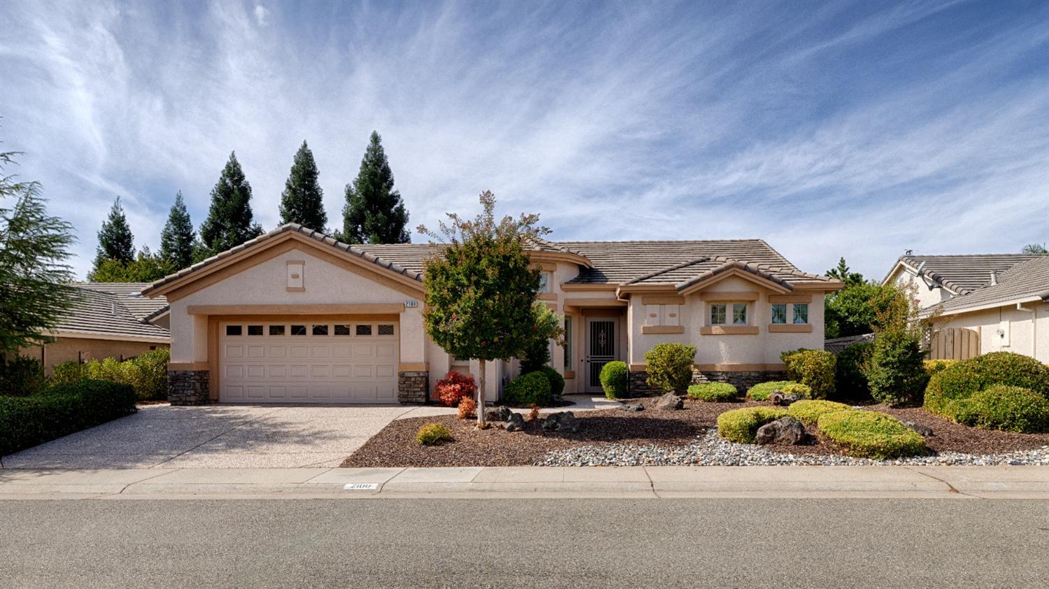 a front view of a house with a yard and trees