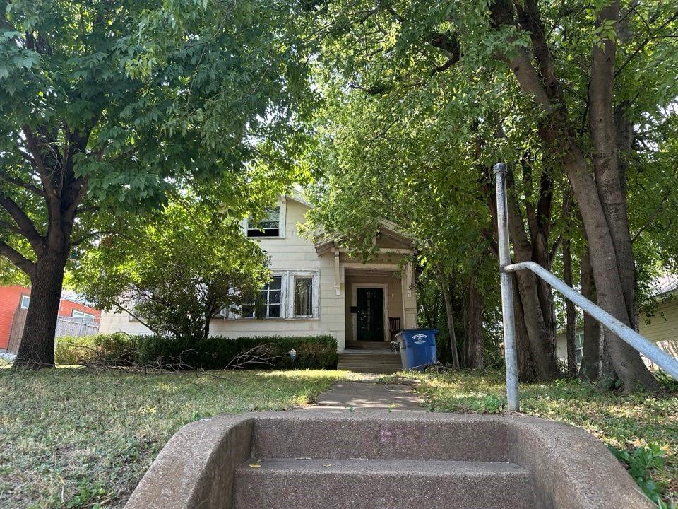 a view of a house with backyard and tree