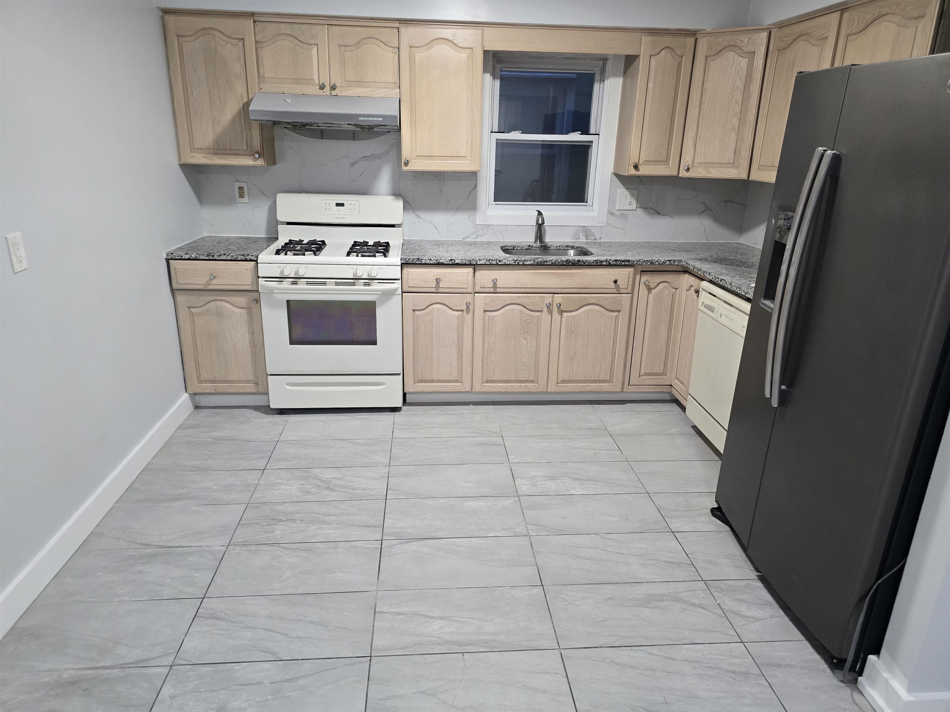 a kitchen with a stove top oven and cabinets