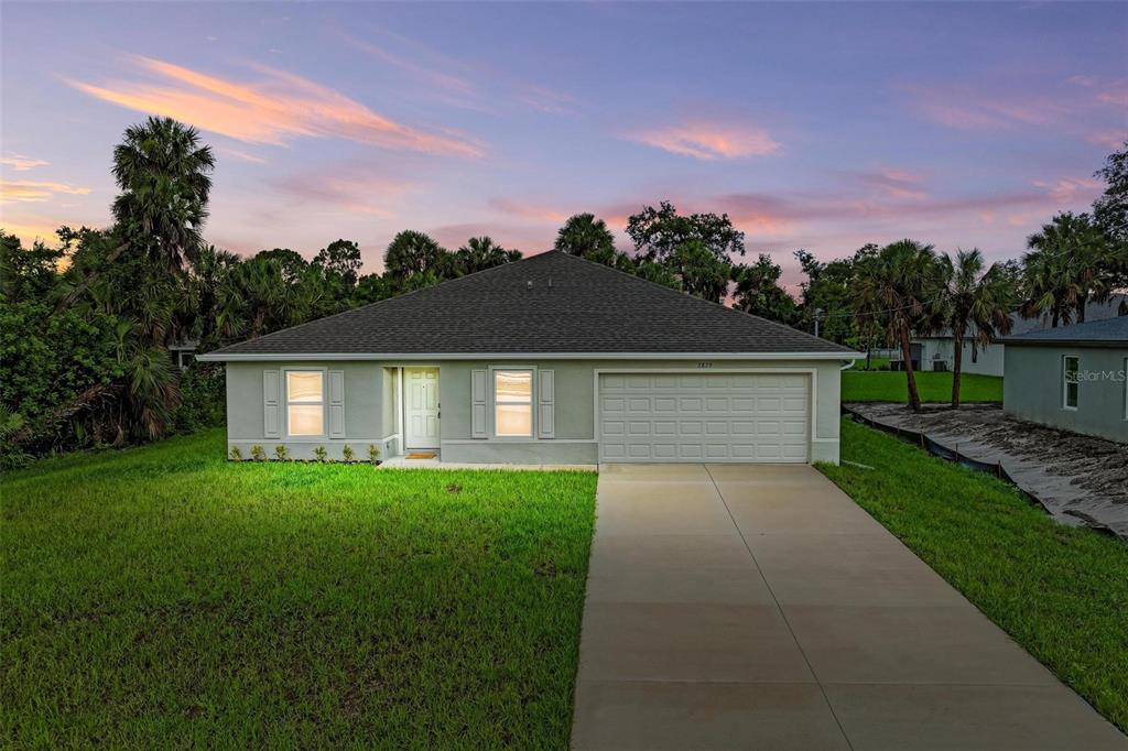 a front view of a house with a yard and garage