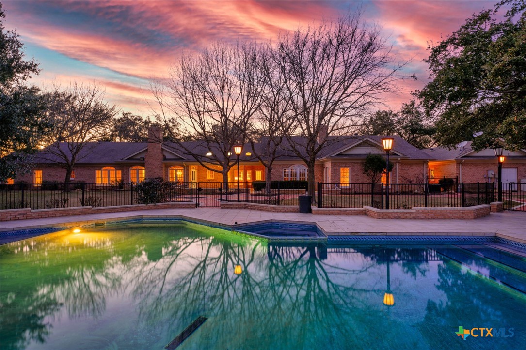 a view of swimming pool with lounge chair and trees