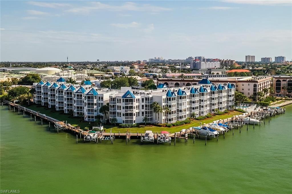 an aerial view of ocean and residential houses with outdoor space