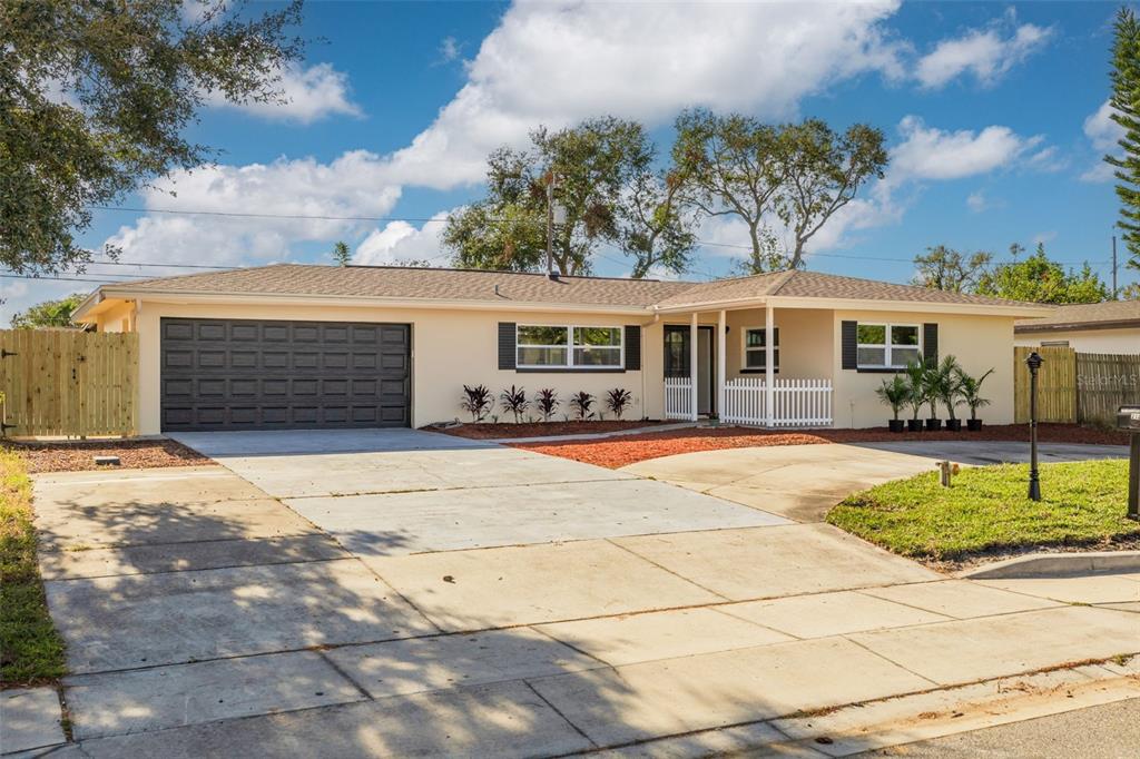 a front view of a house with basket ball court and a garage