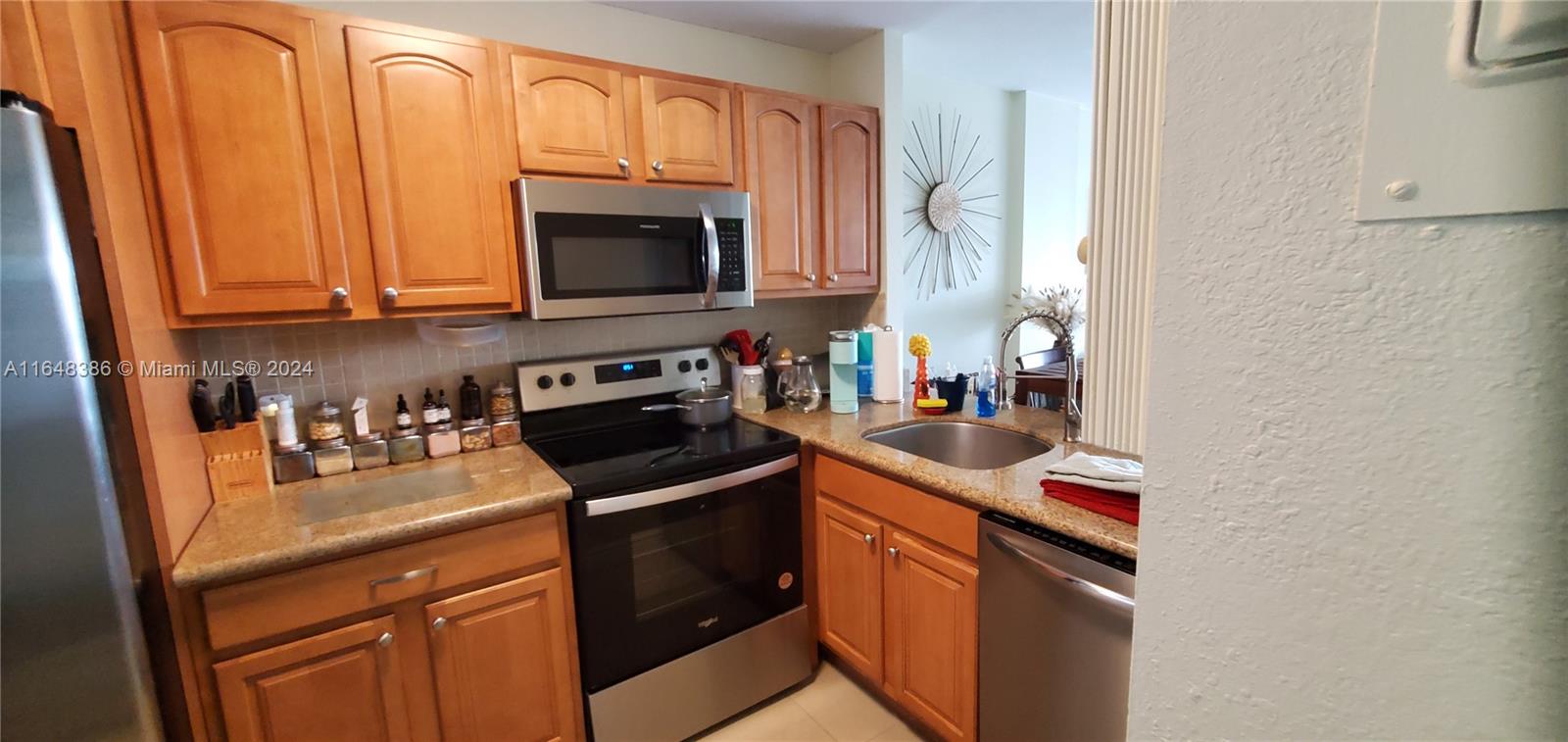 a kitchen with stainless steel appliances granite countertop a sink stove and microwave