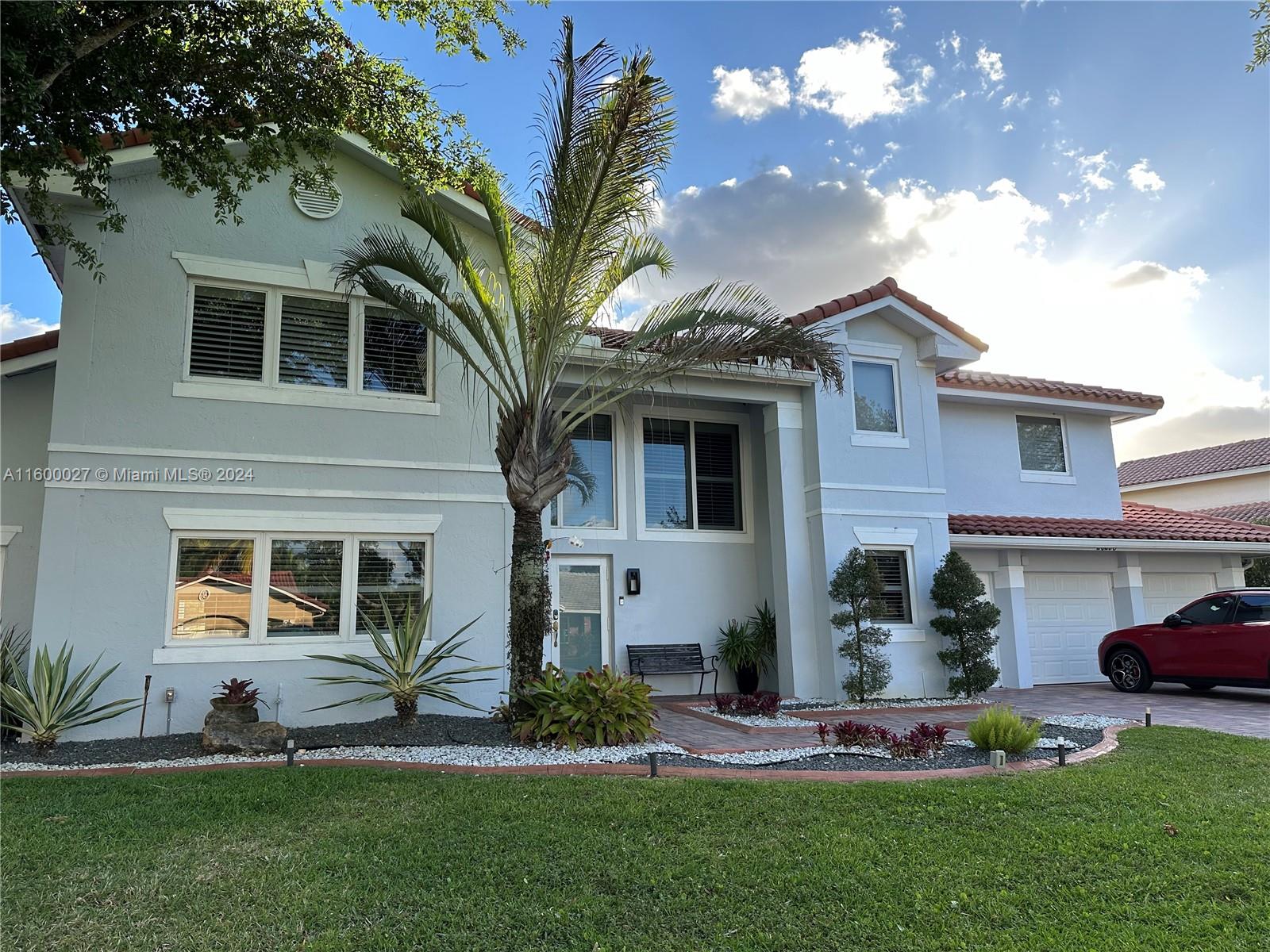 a front view of a house with a garden and plants