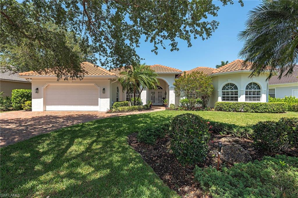 a view of a house with a big yard and large trees