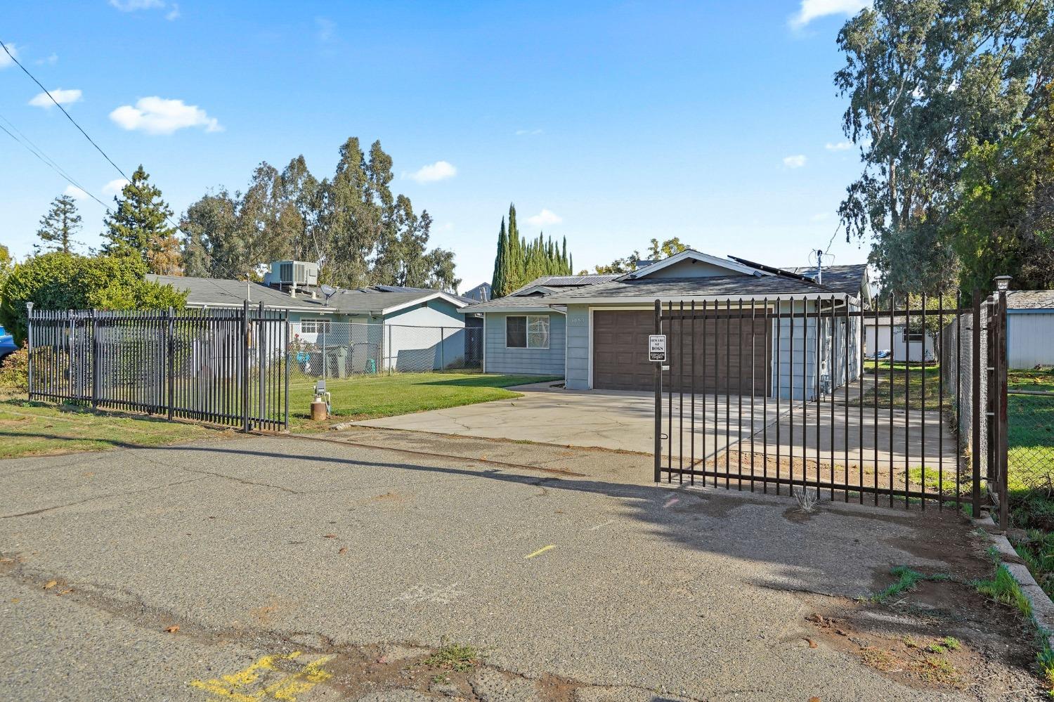 a view of a house with a backyard and a area with wooden fence