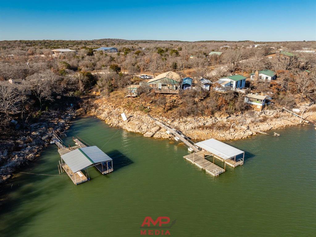 an aerial view of residential houses with outdoor space and lake view