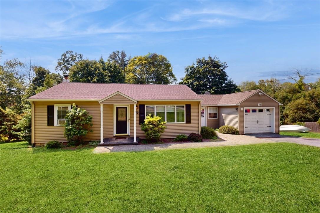 Single story home featuring a garage and a front yard