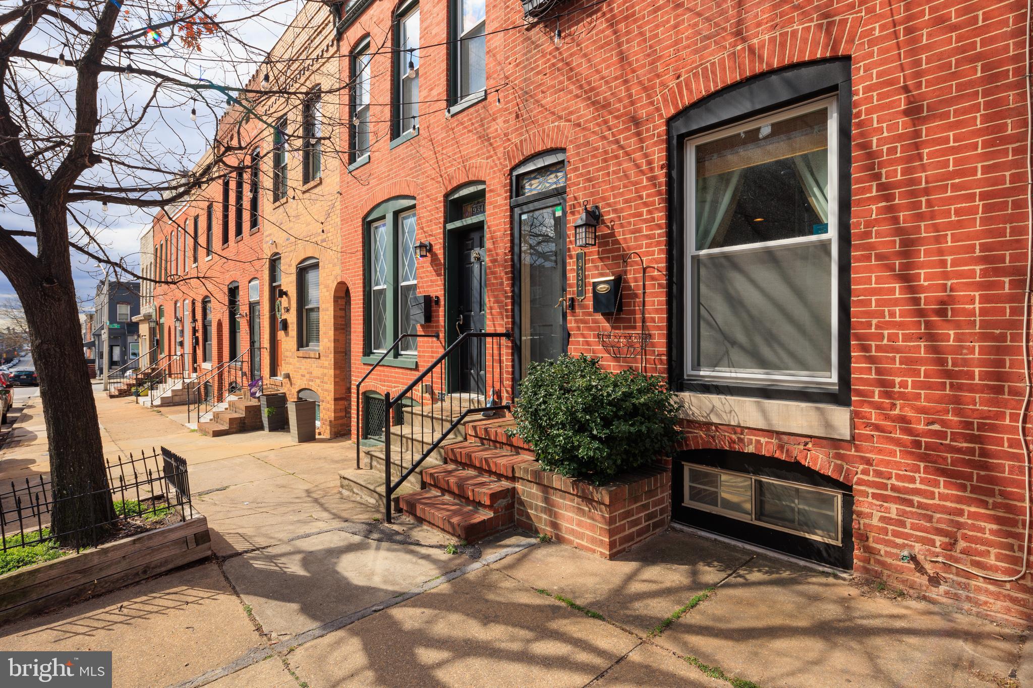 a view of a brick house with many windows next to a road