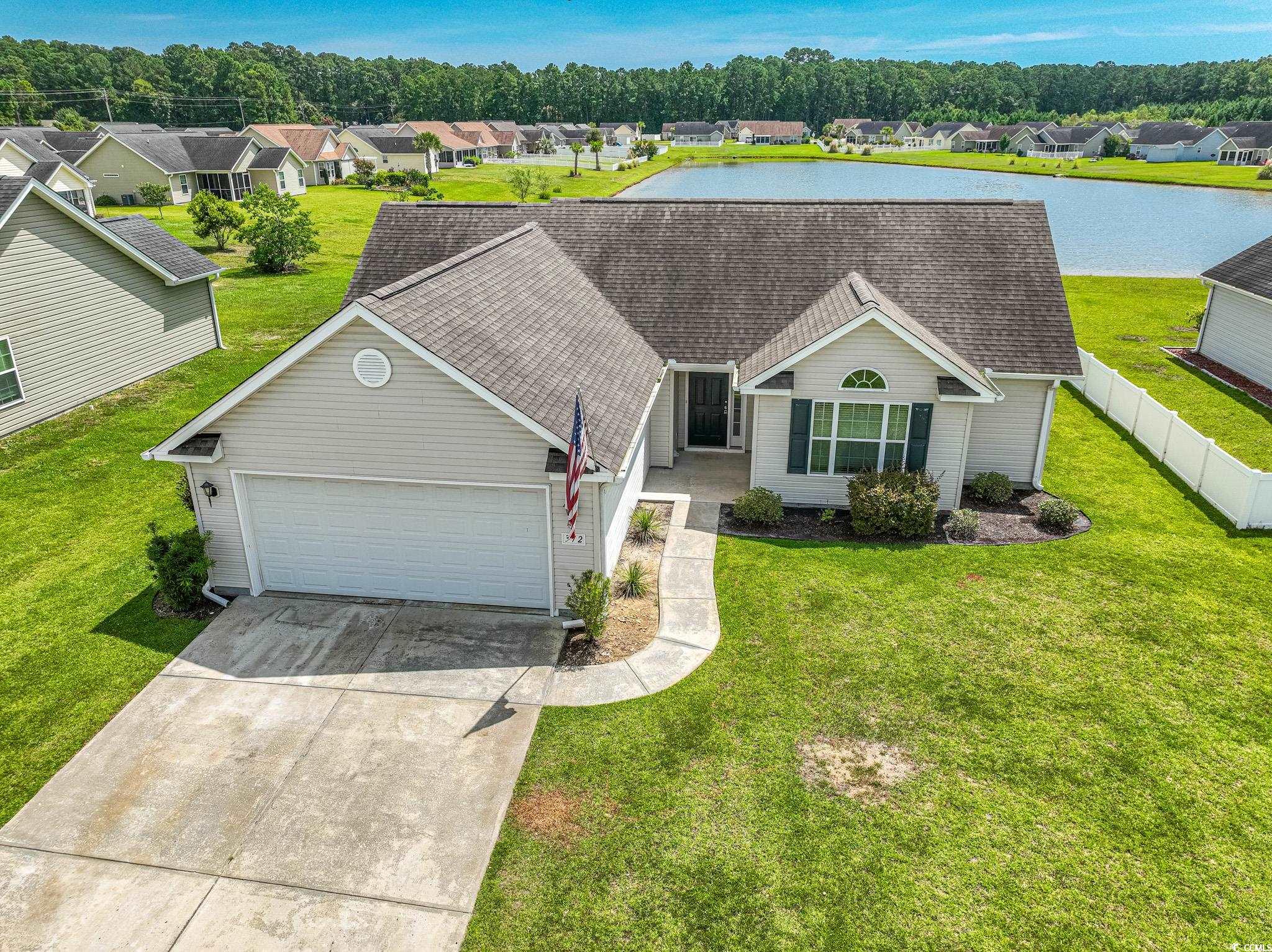 Ranch-style home featuring a front yard and a gara