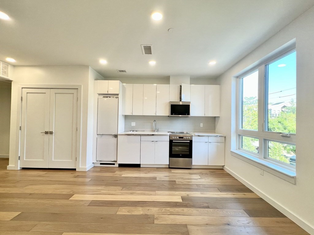 a large kitchen with stainless steel appliances granite countertop a stove and a refrigerator