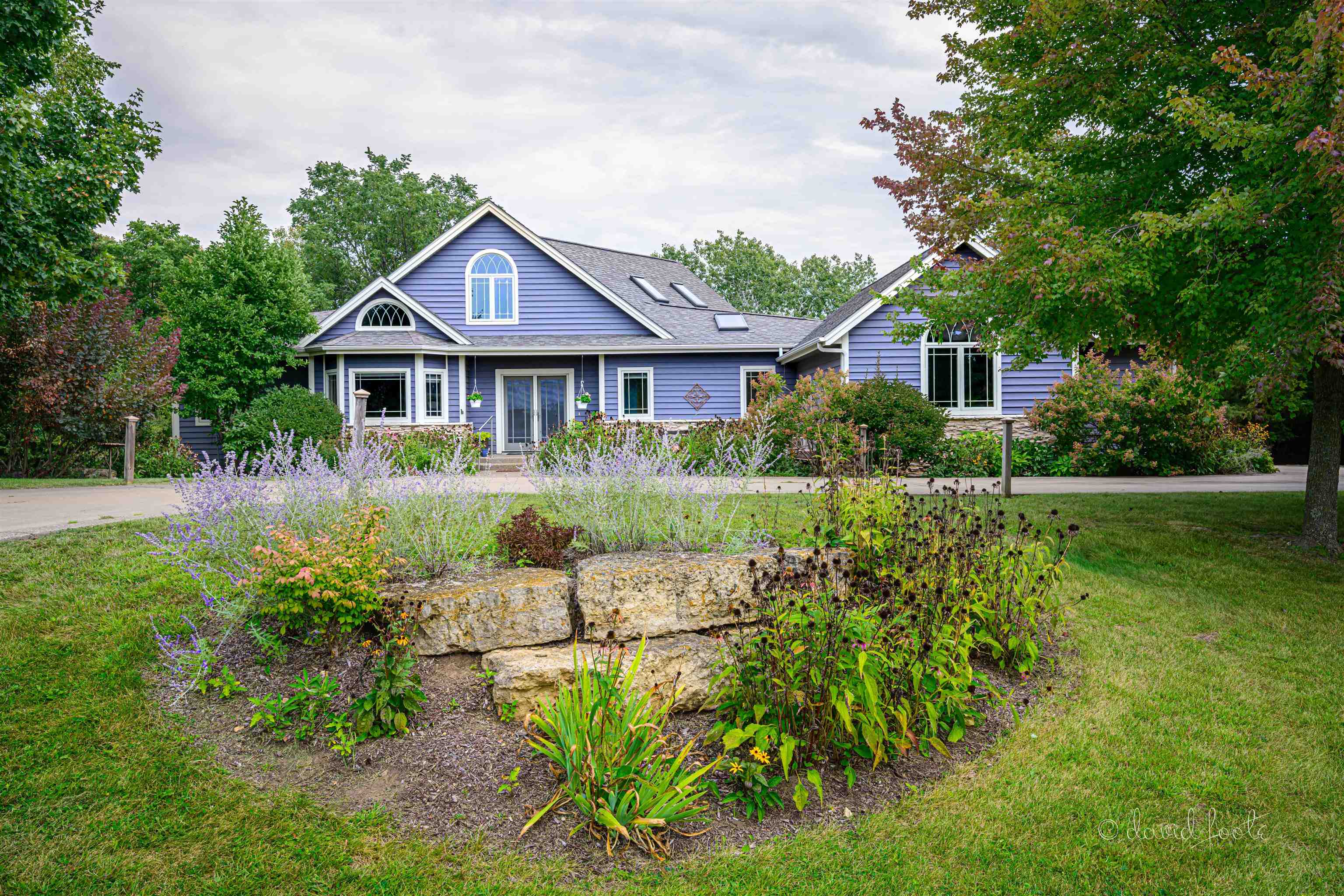 a front view of a house with a yard and potted plants