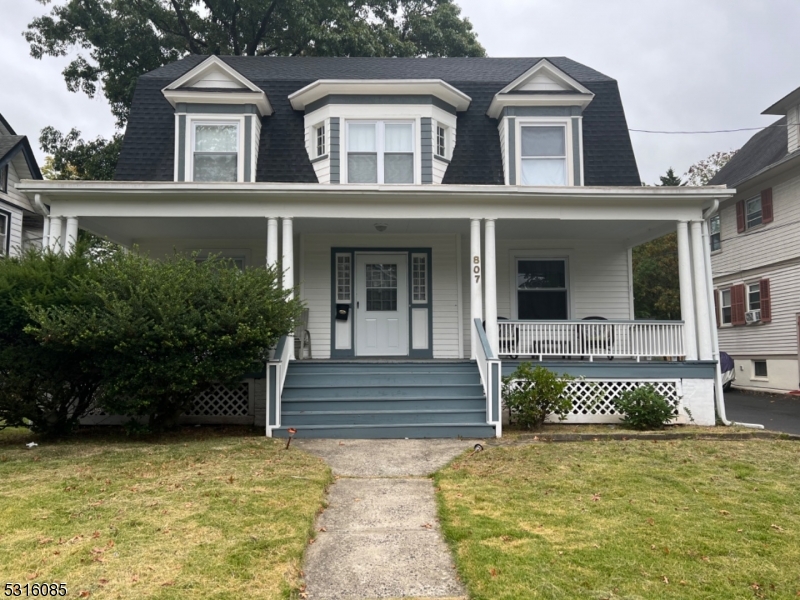 a front view of a house with a yard and potted plants