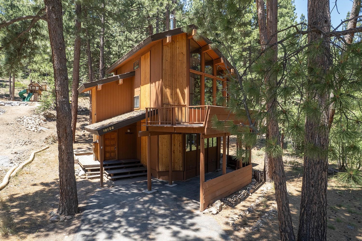 a view of a house with backyard and trees