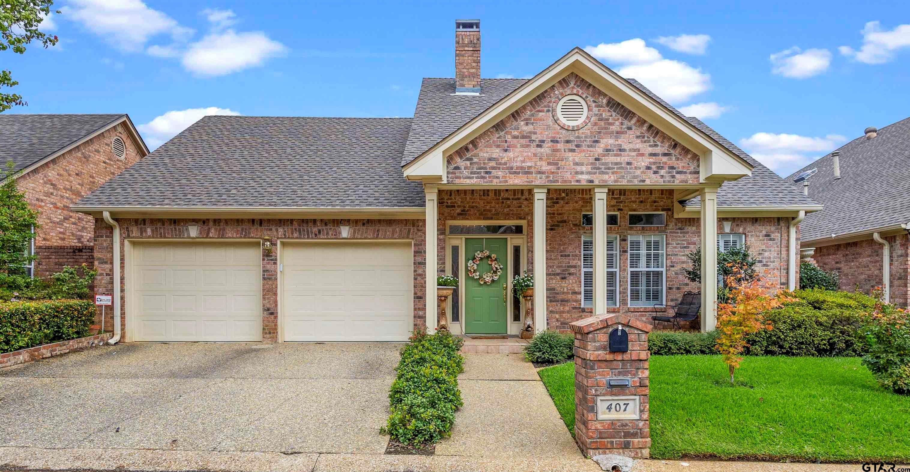 a front view of a house with a yard and potted plants