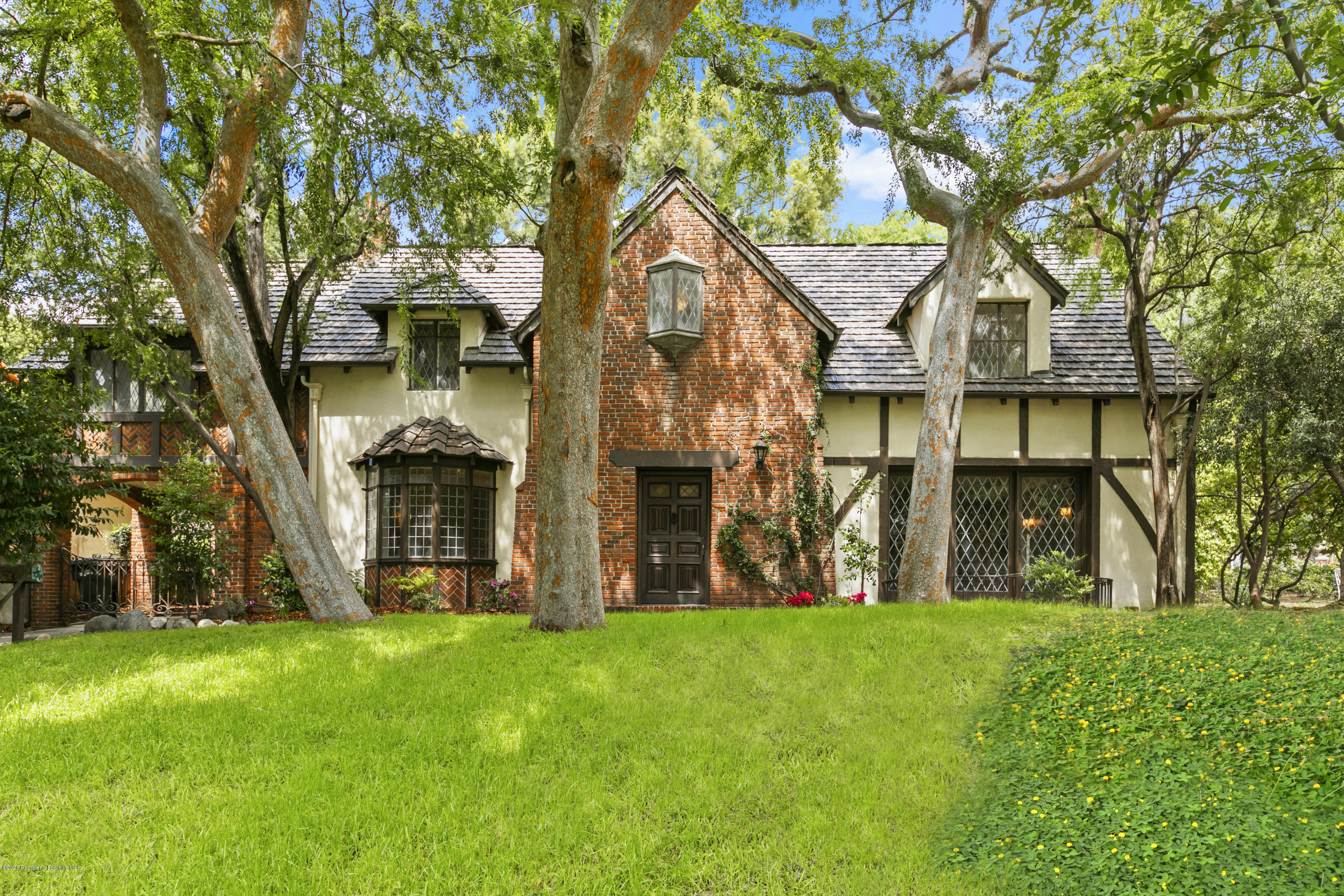 a view of a house with a big yard and large tree