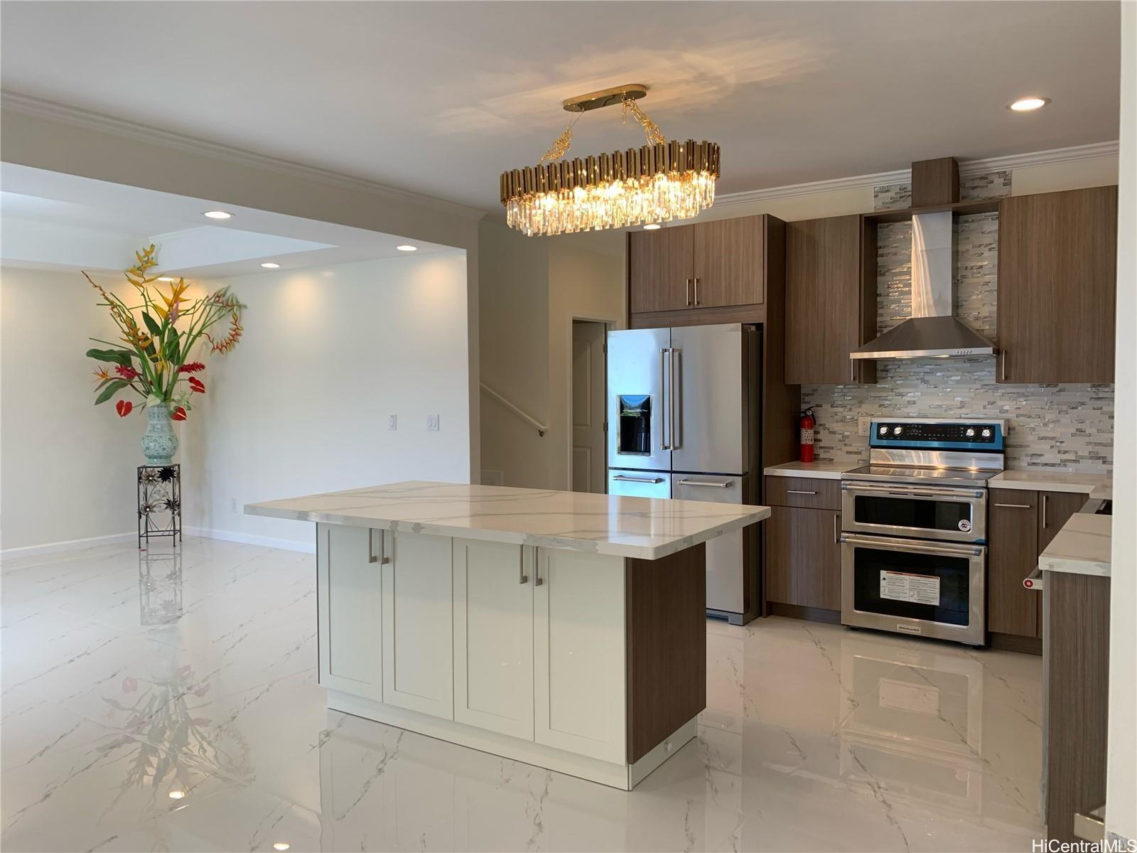 a kitchen with kitchen island granite countertop stainless steel appliances a sink stove and refrigerator