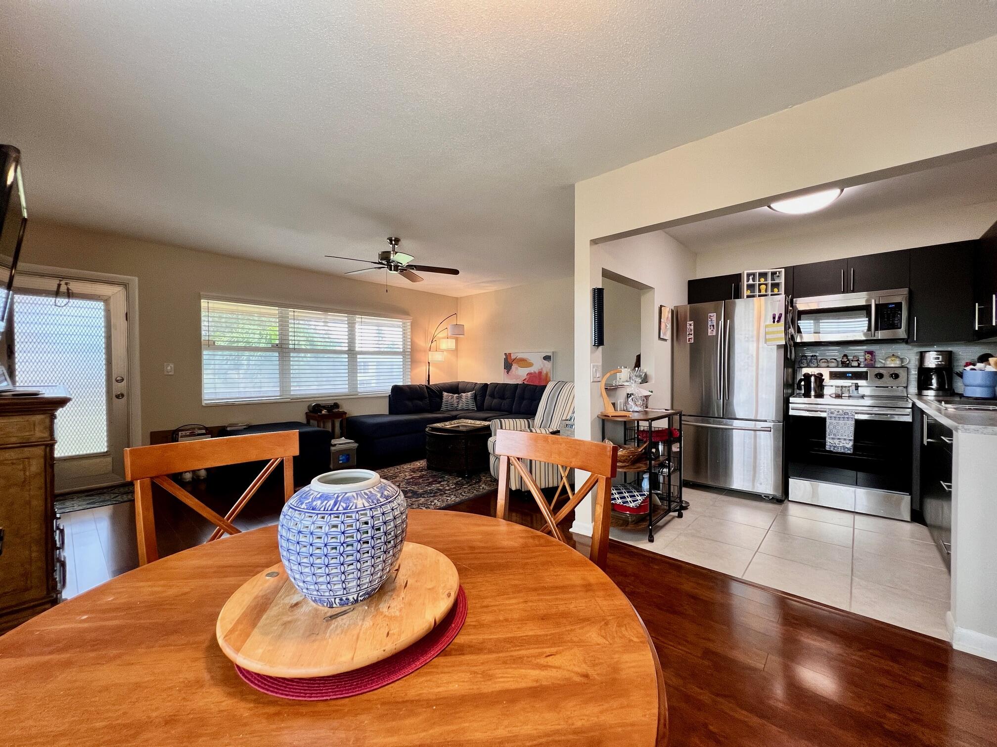 a living room with furniture kitchen view and a wooden floor