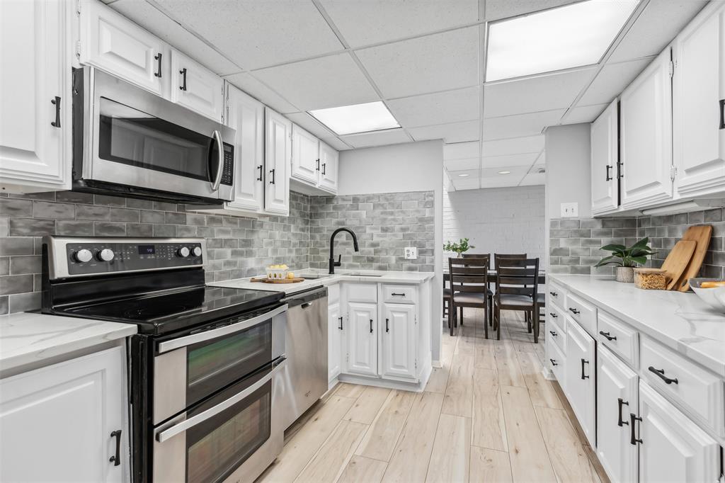 a kitchen with stainless steel appliances a stove sink microwave and cabinets