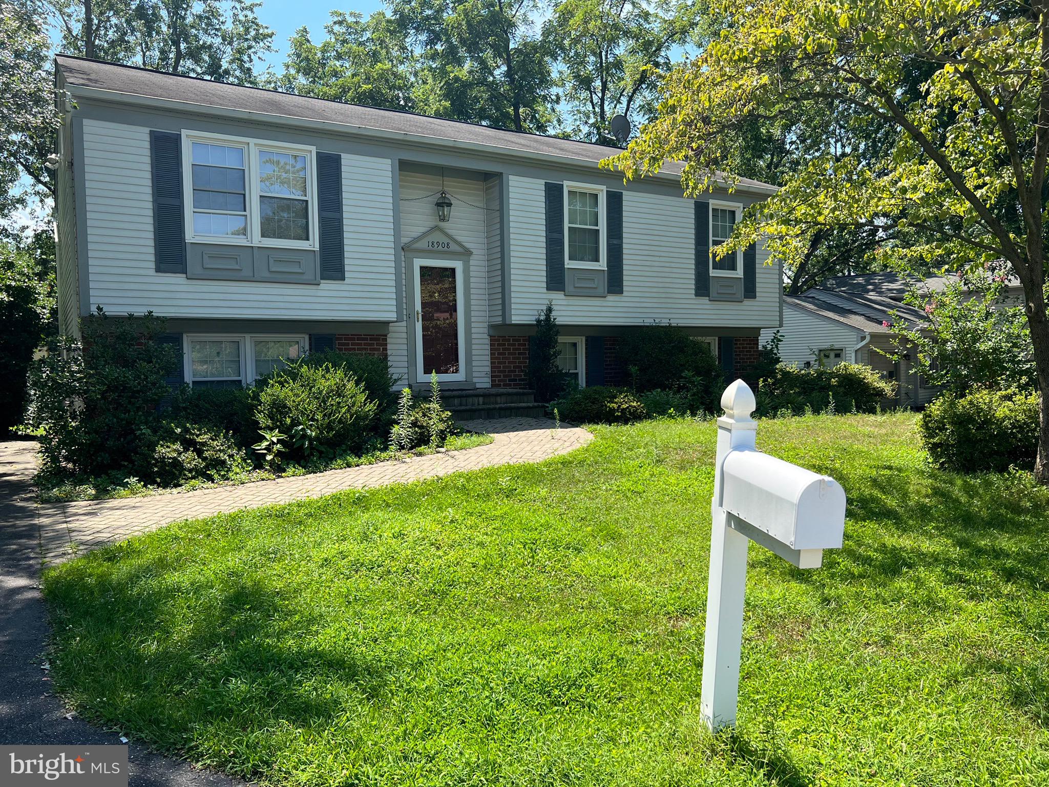 a front view of a house with a yard and trees